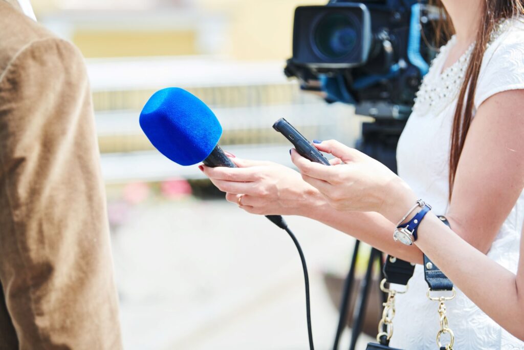 Journalist interviewing someone with a microphone.